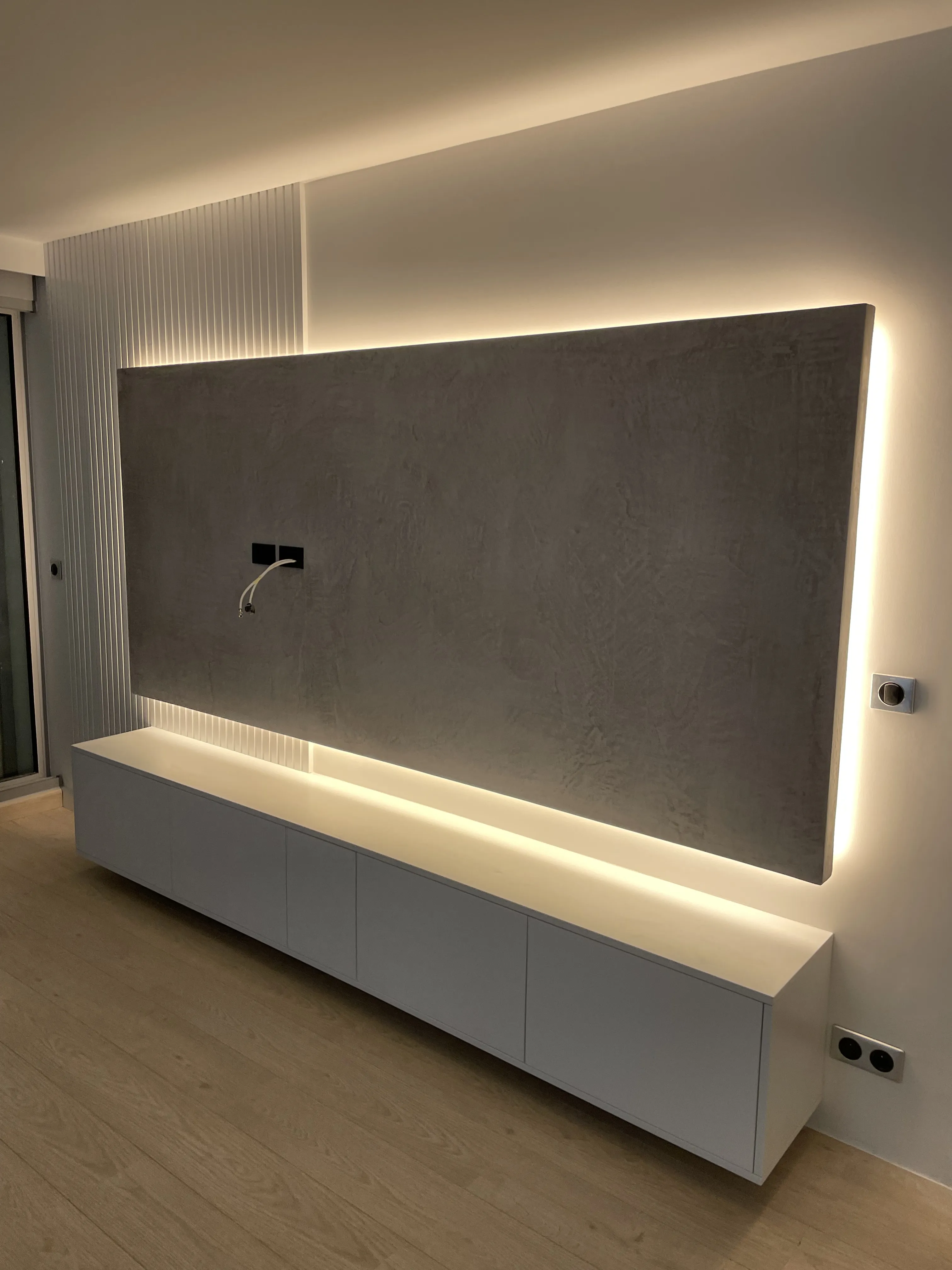 Living moderno con parete attrezzata retroilluminata, ristrutturazione completa