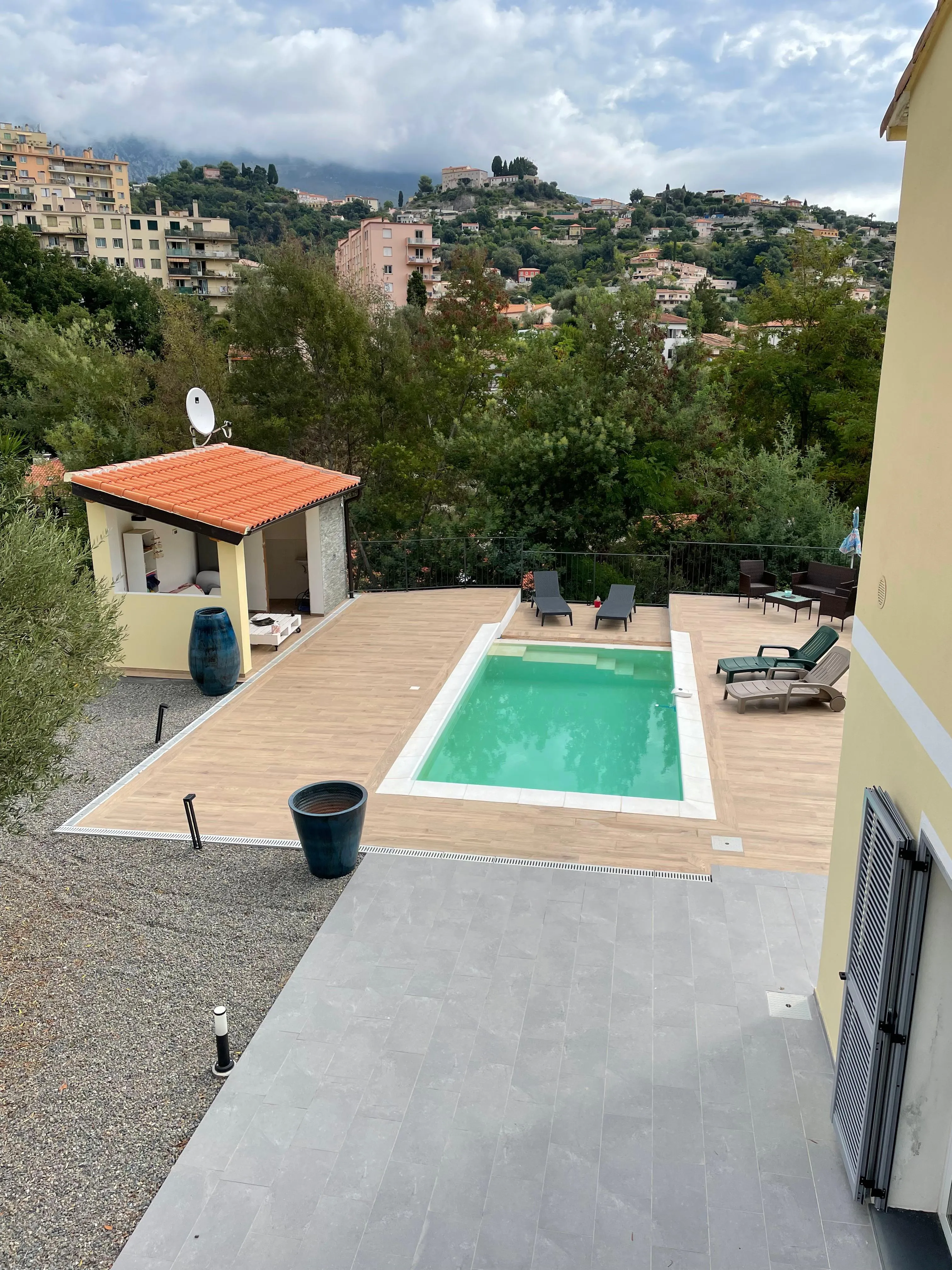 Piscina interrata con rivestimento in gres e muro in pietra naturale