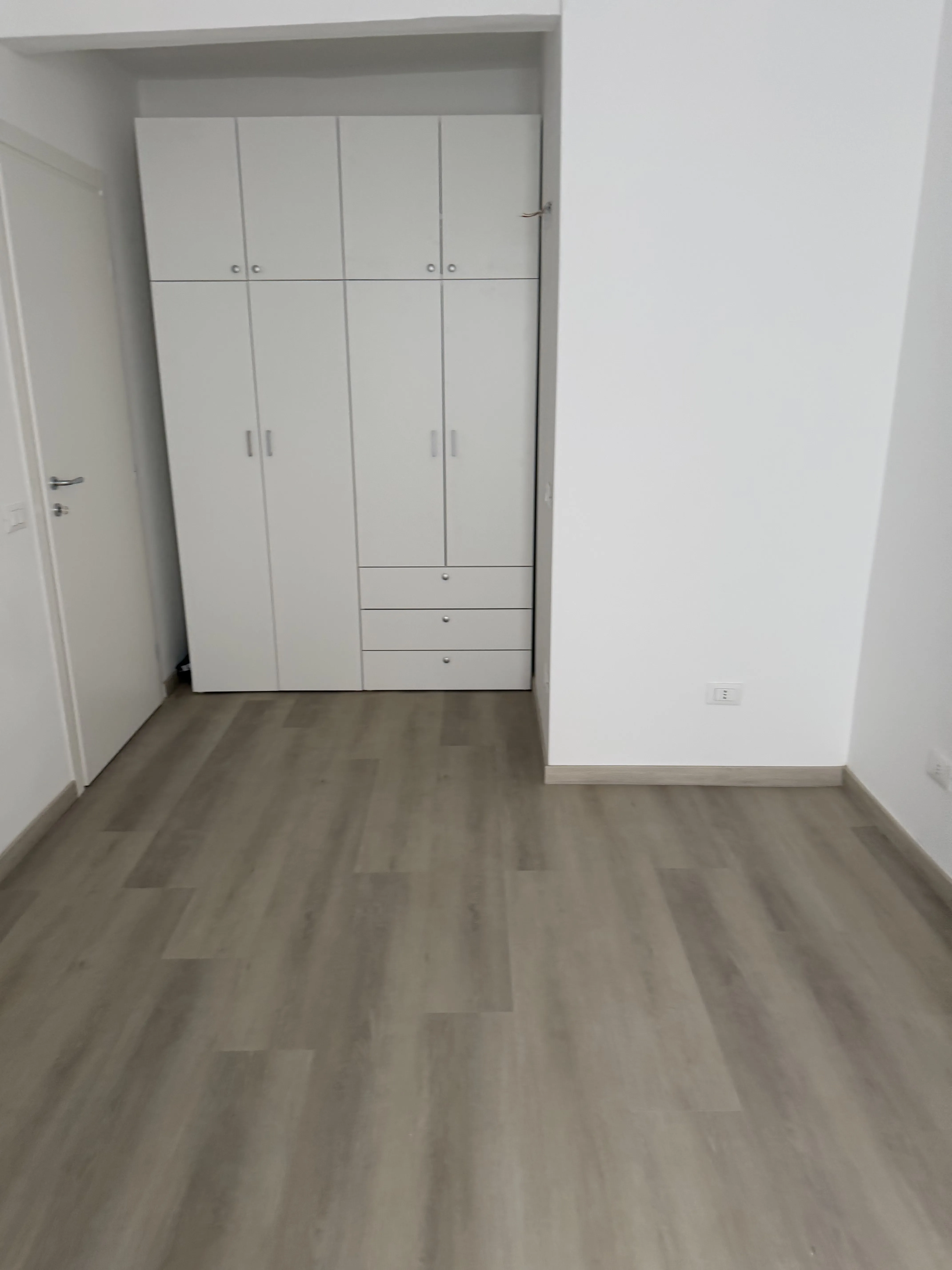 Camera da letto con armadio su misura e pavimento in laminato