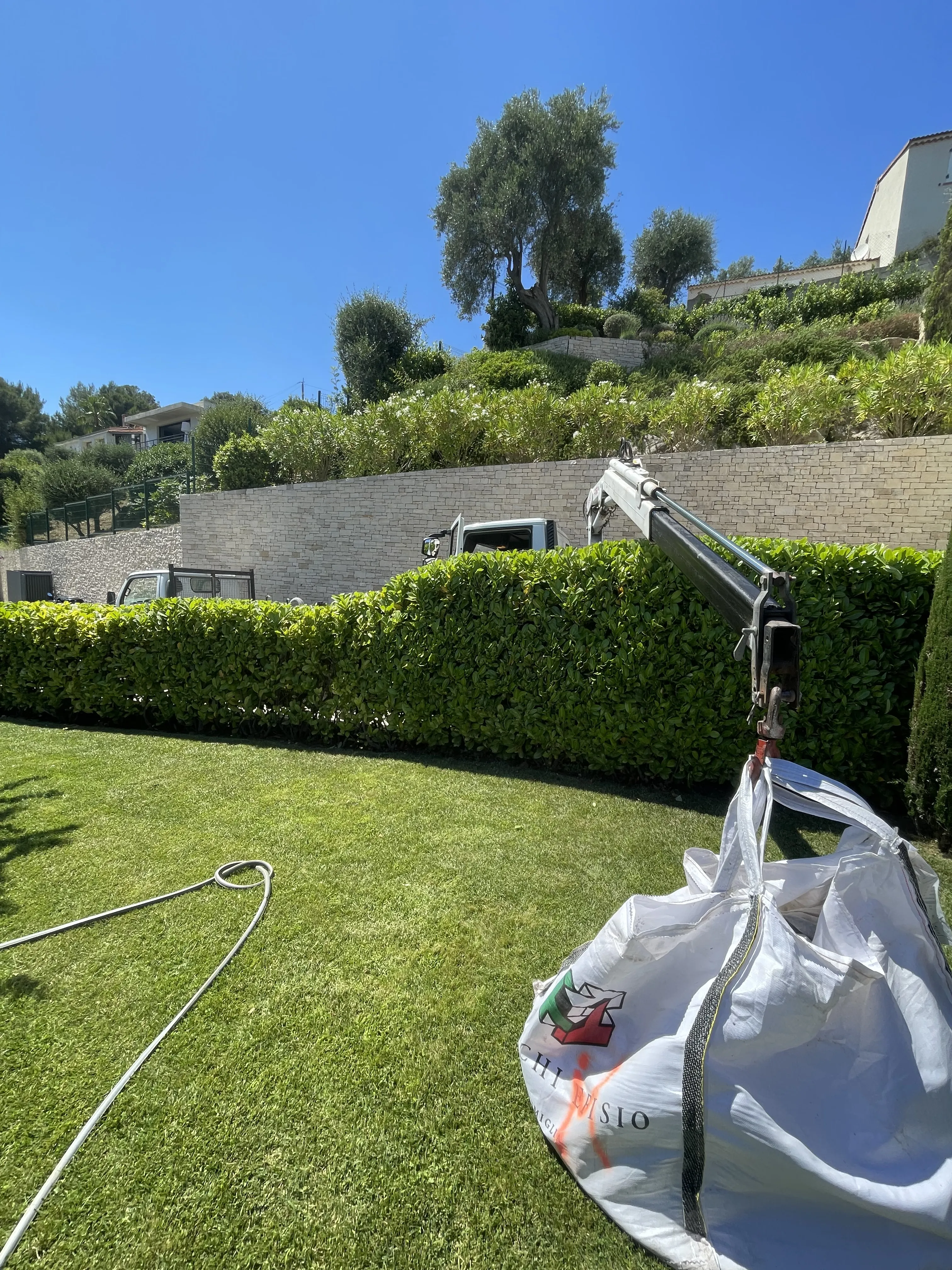 Sollevamento big-bag di materiali in giardino con camion gru