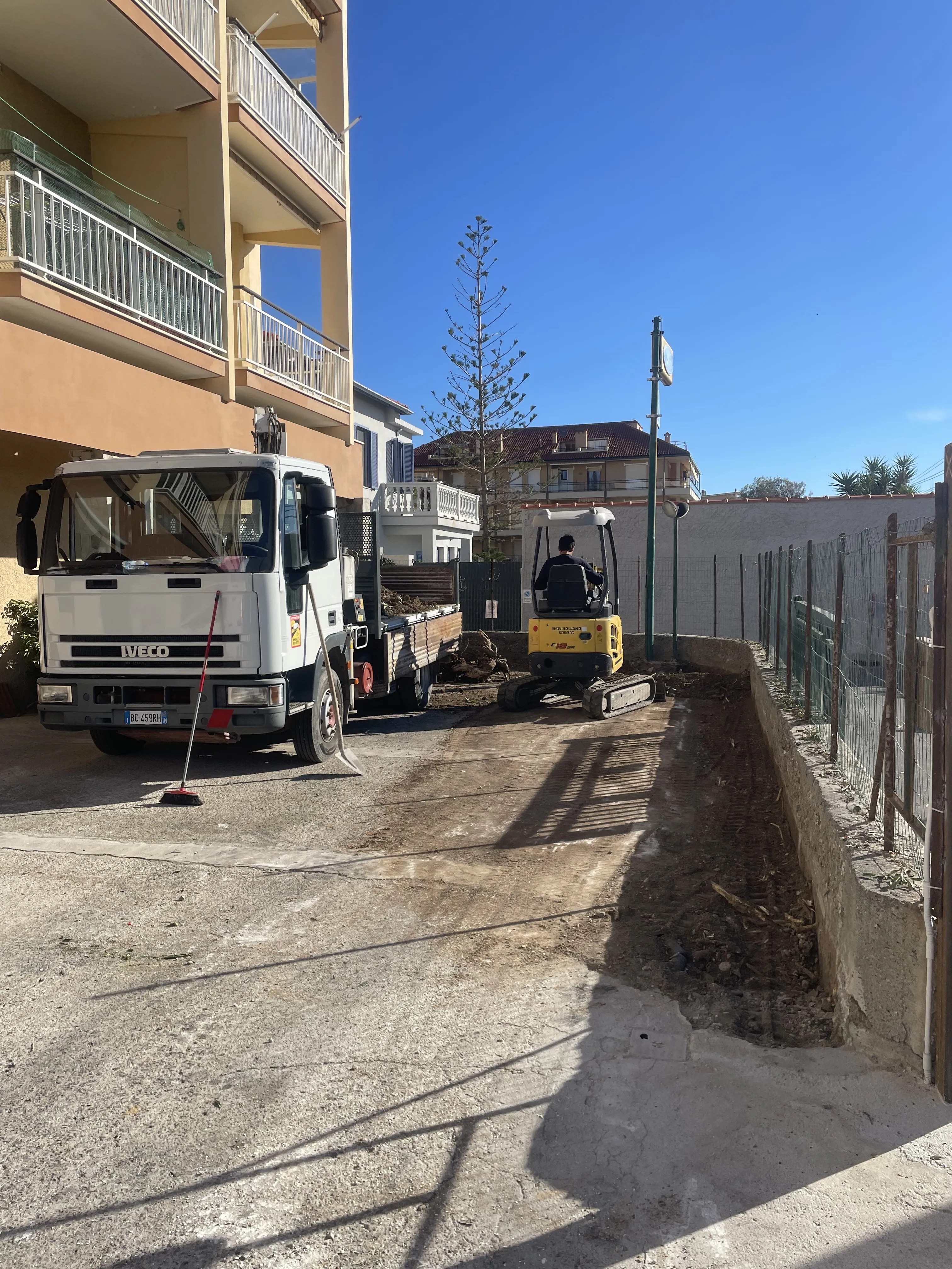 Mini escavatore in scavo di trincea per impianti, condominio in Liguria